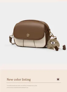 Stylish color-block mini crossbody bag for women, soft leather round shoulder bag with cute fluffy charm.