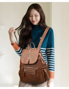Brown leather backpack detail, soft texture, multiple pockets, ideal for daily commute.