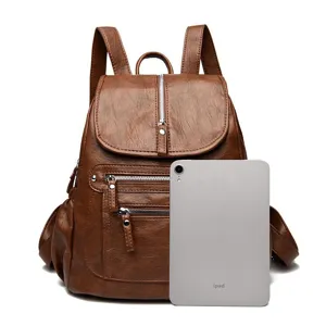 Detail view of the vintage brown leather backpack showcasing multiple zipper pockets.