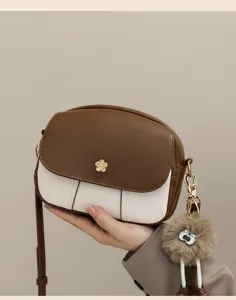 Stylish color-block crossbody bag for women, soft leather mini shoulder bag with cute fluffy charm.