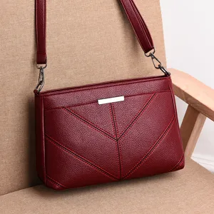Stylish wine red leather women shoulder bag with elegant stitching and metal accent.