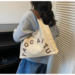 Large capacity canvas tote bag with letter embroidery, stylish shoulder bag for commuting.