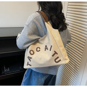 Canvas tote bag for women, large capacity shoulder bag with stylish letters and comfortable handles.