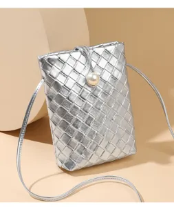 Silver woven mini leather phone bag detail, elegant pearl button closure and slender shoulder strap.