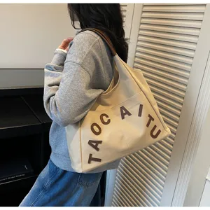 Large capacity canvas shoulder tote bag with stylish brown letter embroidery for daily commute.