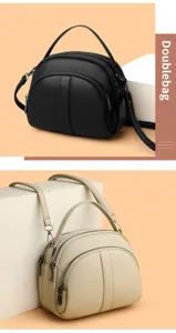 Close-up details of the double zipper dome crossbody bag, showcasing premium texture and hardware.
