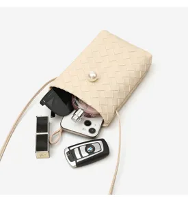 Detailed view of the mini woven leather crossbody phone bag, showcasing interior capacity and design.