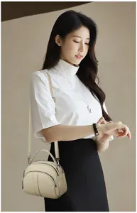 Detail shot of the stylish beige crossbody bag featuring multiple zipper compartments and elegant design.