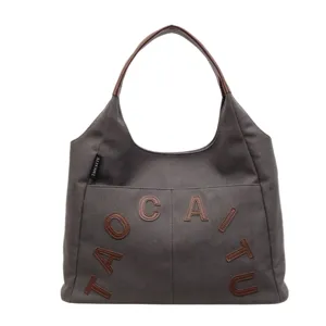 Dark grey canvas tote bag with brown leather handles and chic letter appliques for women daily.