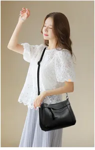 Close up view showing the detailed texture and strap design of this stylish black leather bag.