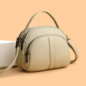 Elegant beige dome crossbody bag for women, versatile single shoulder fashion handbag.