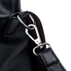 Close-up detail of the durable silver metal clasp and strap connector on a black leather handbag.