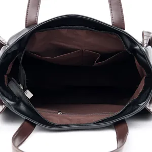 Detailed view of women's leather tote bag interior with multiple pockets and zipper.