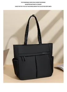 Black commuter tote bag detail showing double handles, front pocket and durable fabric.