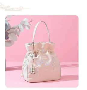 Close-up detail of Chinese style embroidered bucket bag with delicate floral pattern and beads.