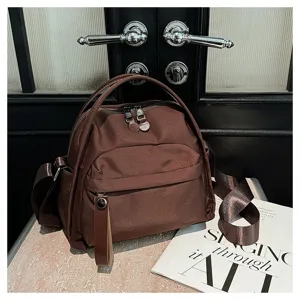 Brown nylon crossbody bag detail showcasing durable fabric texture, zipper pocket, and handle.