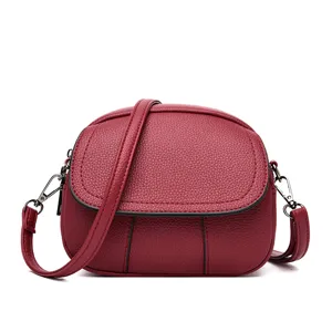 Red mini crossbody bag, stylish soft leather shoulder bag with chic round flap and metal hardware.