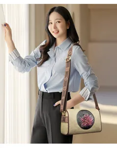 Chic women shoulder bag with embossed lotus and patterned strap for stylish daily commute.