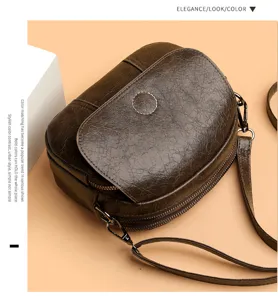 Dettaglio ravvicinato di elegante borsa a tracolla in pelle marrone scuro con zip.