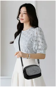 Elegante borsa a tracolla nera da donna con patta e particolare finitura effetto cocco.