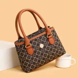 Retro Kleeblatt Monogramm kleine Tasche mit braunen Ledergriffen und schickem Metallknopf.