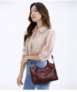 Borsa a tracolla in pelle rosso vino, dettaglio di borsa elegante con tracolla.