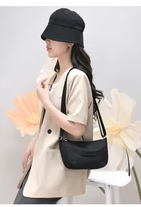 Detail view of black nylon crossbody bag worn by model, casual daily wear shoulder bag style.