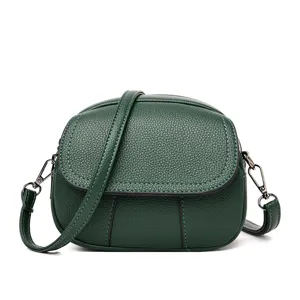 Detailed view of the dark green mini crossbody bag showing soft leather texture and metal hardware.