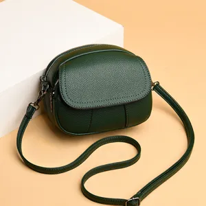 Dark green mini crossbody bag detail, soft leather round shoulder bag with adjustable thin strap.