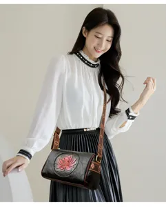 Detailed shot of women's floral embossed shoulder bag worn by model, showing texture and strap.