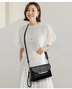 Elegant black leather crossbody bag for women, featuring a chic metal clasp and strap.