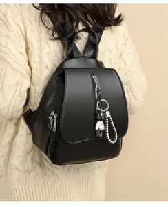 Detailansicht des stilvollen schwarzen Leder-Freizeitrucksacks mit süßem Bären-Schlüsselanhänger.