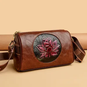 Retro brown leather cylinder crossbody bag with exquisite embossed pink lotus flower for women.