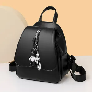 Stylischer schwarzer PU-Leder Rucksack für Damen mit niedlichem Bärenanhänger und Fronttasche.