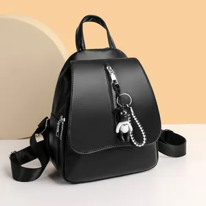 Stilvoller schwarzer Damen Rucksack aus Kunstleder, lässige Alltagstasche mit süßem Bärenanhänger.