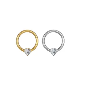 Anillo segmentado de titanio con circonita en forma de corazon para piercing, oro y plata.
