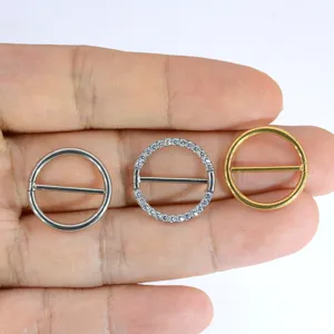 Detail view of 14G body piercing jewelry, featuring plain metal and crystal paved round nipple rings.