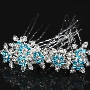 Gros plan d'épingles à cheveux en strass bleu et transparent avec joli motif de flocon.