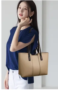 Elegant khaki tote bag detail with dark brown straps, stylish minimalist design view.