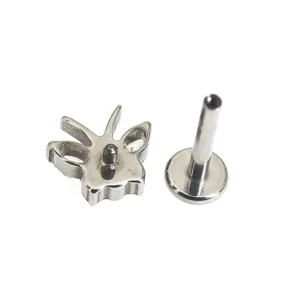 Detailopname van titanium vlinder labret piercing sieraad met schroefdraad en topdeel.