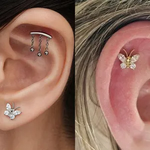 Gedetailleerd overzicht van G23 titanium vlinder piercing sieraden en kraakbeen oorbellen op oor.