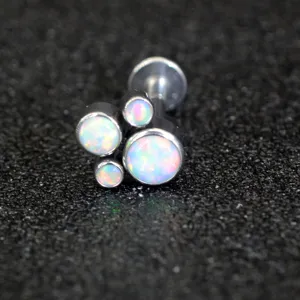 Steel opal cat paw piercing detail, close up shot of cartilage labret stud jewelry piece.
