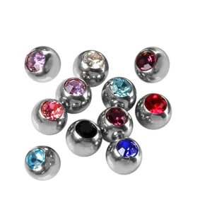 Stainless steel piercing ball close-up detail, colorful crystal inlaid body jewelry accessory.