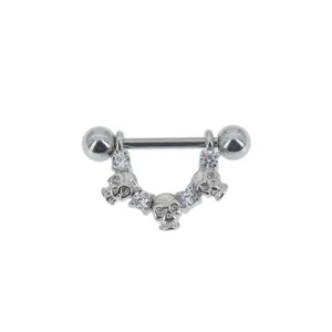 Detailed view of a silver skull nipple ring and cartilage piercing with clear zirconia.