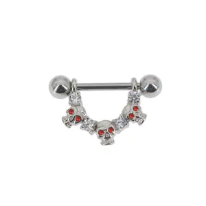 Close-up detail of punk style skull piercing jewelry with sparkling clear and red gems.