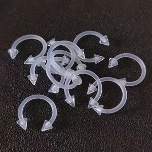 Detaillierte Nahaufnahme von transparenten Acryl Hufeisen Piercingringen für den Körper.