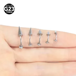 Detailed view of G23 titanium curved barbell lip and cartilage piercing studs with spike ends.