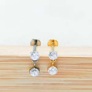 G23 titanium double cubic zirconia dangling labret stud and ear cartilage piercing detail.