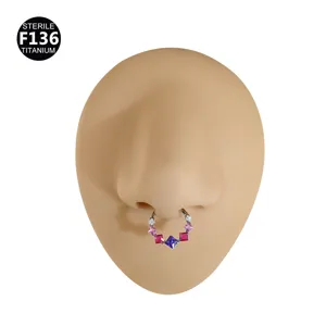 Dettaglio anello setto in titanio, gioiello piercing con zirconi quadrati colorati.