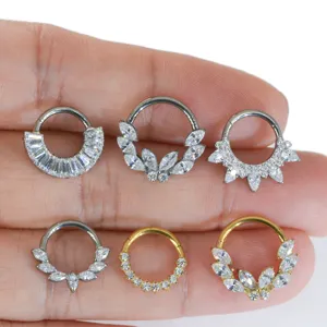 Detailed view of titanium hinged segment rings with cubic zirconia crystal styles for body piercing.